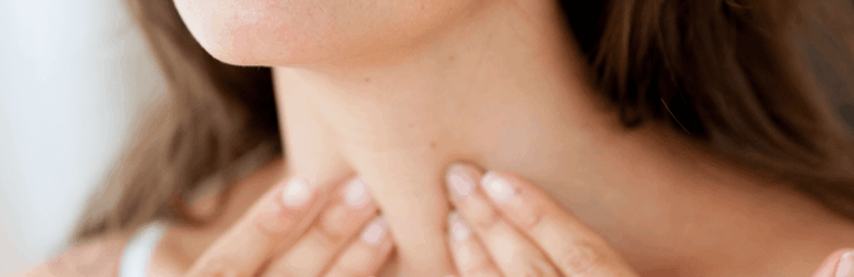 Mulher examinando o pescoço na região da tireoide.
