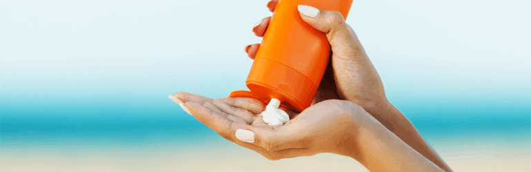 Pessoa colocando protetor solar na mão para passar no corpo.