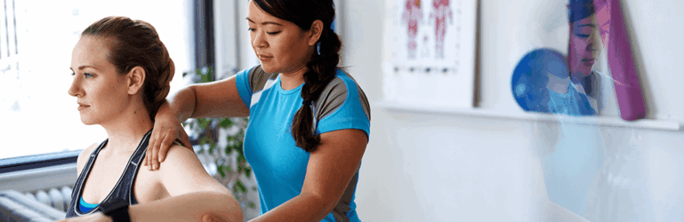 Médica examinando o ombro e braço de paciente.