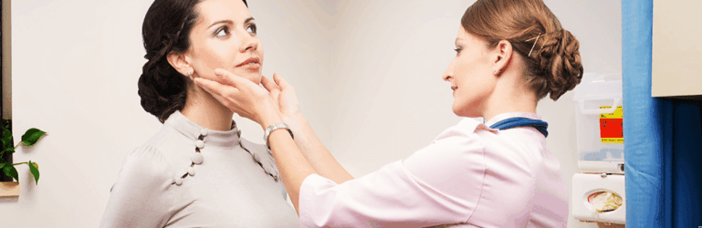 Médica examinando o pescoço de paciente.